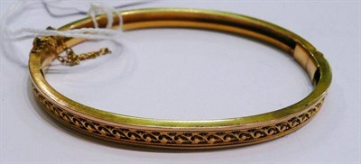 Lot 407 - A hinged bangle with scroll decoration