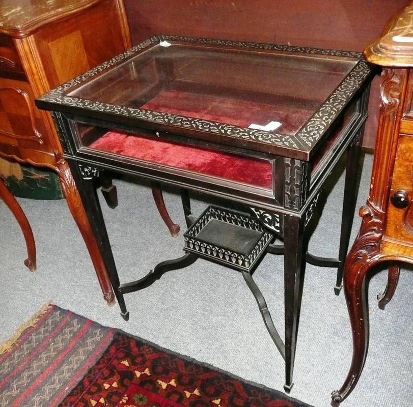 Lot 642 - An ebonised curio table on square tapering legs *