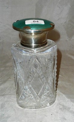 Lot 84 - A large cut glass perfume bottle with silver and green guilloche enamel cover