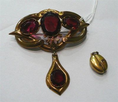 Lot 93 - A small locket and a base metal Victorian brooch set with red paste stones