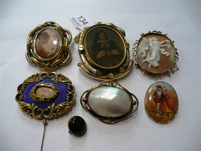 Lot 134 - A cameo brooch, three locket brooches, a mother-of-pearl brooch and a ceramic brooch