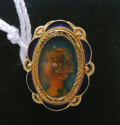 Lot 343 - A portrait ring, within a blue enamelled border, stamped '750'