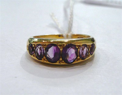 Lot 360 - An 18ct gold amethyst half hoop ring, with engraved shoulders