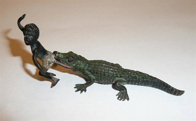 Lot 365 - A cold painted bronze model of a crocodile biting a negro boy's bottom