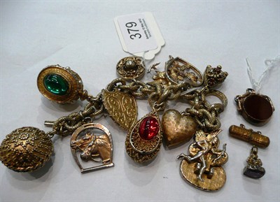 Lot 379 - A gold coloured bracelet with charms, a 9ct gold cornelian charm and two other others (4)