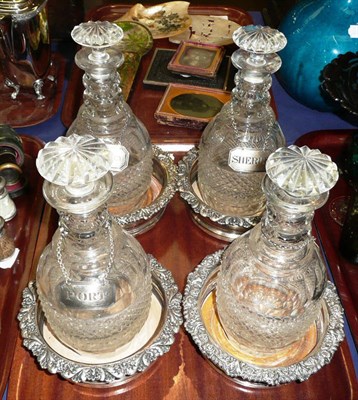 Lot 418 - Four 19th century glass decanters with silver labels, and four plated bottle coasters