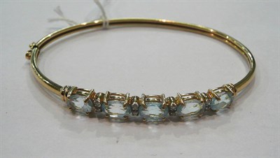 Lot 505 - A bangle set with blue topaz and diamonds