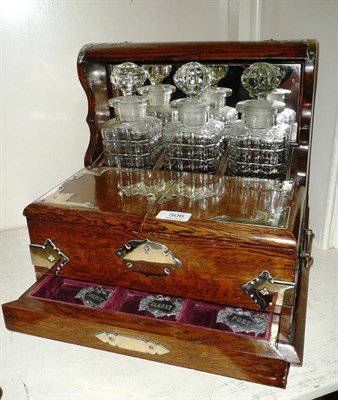 Lot 506 - An Edwardian oak three bottle tantalus/games compendium, with plated strapwork mounts, the...