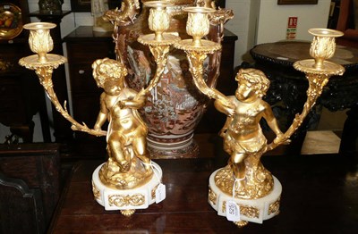 Lot 525 - After Clodion: a pair of gilt bronze figural candelabra, each as a Bacchic cherub sitting on a...