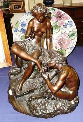 Lot 531 - A 20th century bronze figure group of a lady seated on a rocky base