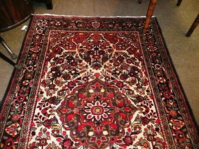 Lot 671 - Lilihan Rug, West Persia The ivory field with flowering plants around a central medallion framed by