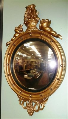 Lot 833 - A Regency style gilt convex wall mirror with ebonised slip