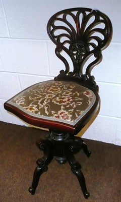 Lot 859 - A late Victorian mahogany revolving piano seat, late 19th century, the pierced fan shape back...