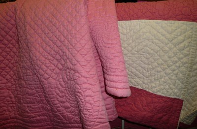 Lot 1082 - Pink and white striped reversible quilt, 215 cm by 240 cm and a plain pink quilt, 225 cm by 250...