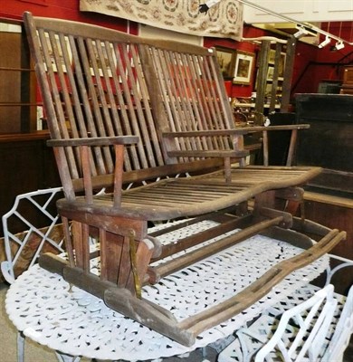 Lot 1094 - A teak double rocking chair