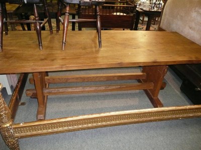 Lot 1104 - An elm refectory table, on shaped supports joined by two stretchers, carved with a woodpecker