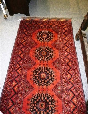 Lot 1107 - A narrow Afghan Turkman runner Northern Afghanistan The brick red field with a column of flowerhead