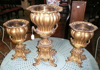 Lot 1150 - Set of three gilt metal campana shaped urns