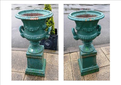 Lot 1156 - A pair of green painted cast iron campana urns, 19th century, with everted gadrooned rims hung with