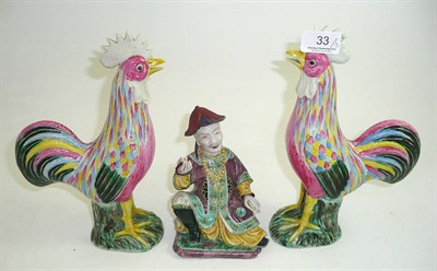 Lot 33 - Pair of 20th century Chinese famille rose cockerels and a figure of a seated Mandarin (3)