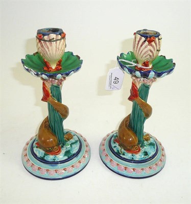 Lot 49 - A pair of Royal Worcester Majolica candlesticks with stylised dolphins and shell motifs