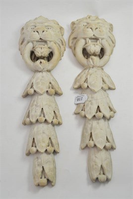 Lot 238 - A pair of carved white marble lion mask and laurel reliefs