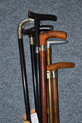 Lot 272 - An ebony walking stick with stylised handle stamped '900', two ebonised walking sticks with...