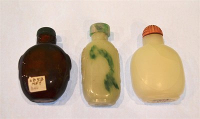 Lot 598 - A Chinese glass snuff bottle imitating jade, of flattened spade shape with taotie mask and ring...