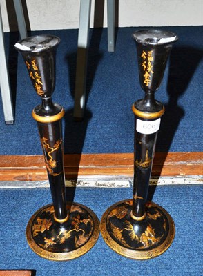 Lot 606 - Two black japanned candlesticks