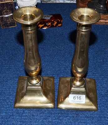 Lot 616 - A pair of Georgian brass candlesticks