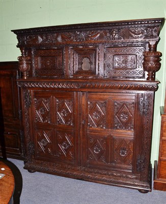 Lot 642 - An impressive carved oak court cupboard, the frieze richly carved with dragons and figural...