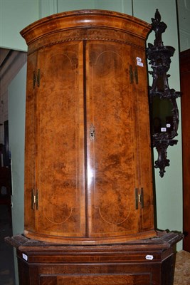 Lot 651 - A walnut bow corner cupboard (with key)