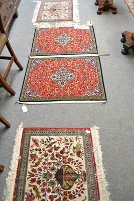 Lot 744 - A pair of silk mats probably Ghom Central Persia, each with an urn issuing flowers flanked by birds