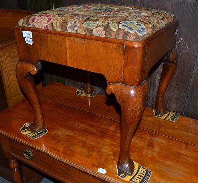 Lot 779 - A walnut dressing stool with floral drop-in seat