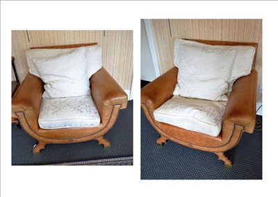 Lot 864 - Two leather covered cross framed armchairs