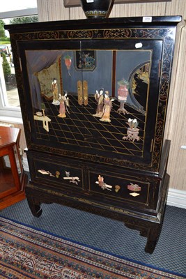 Lot 879 - A 20th century japanned cabinet fitted with two cupboard doors with two drawers below