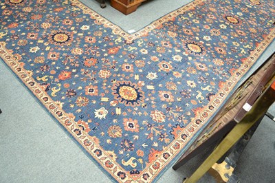 Lot 1143 - Pakistani hand knotted L shaped carpet, the pale indigo field of floral design enclosed by...