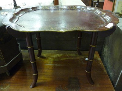 Lot 1147 - A red papier mache tray on a later bamboo simulated stand