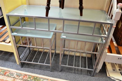 Lot 1201 - A modern chrome and glass top table with a pair of matching lamp tables and a stool