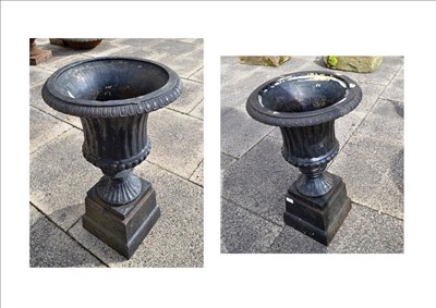 Lot 1280 - A pair of black painted cast iron urns on stands