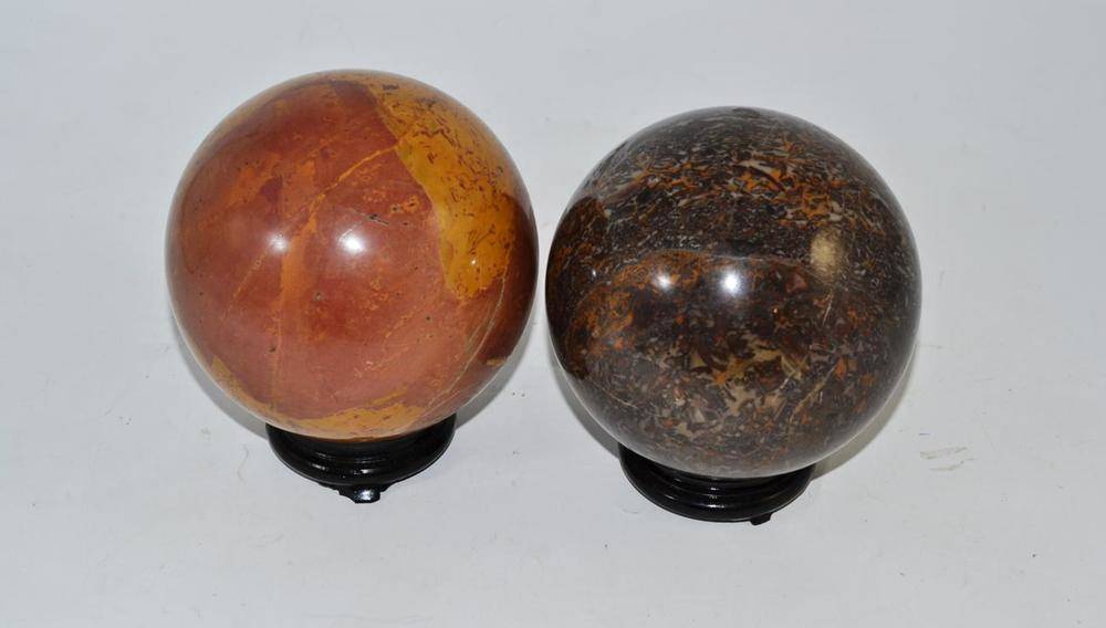 Lot 30 - Two polished hardstone decorative spheres on wooden stands