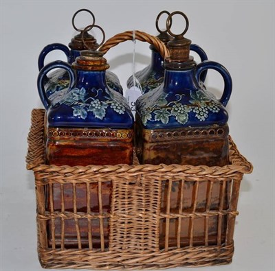 Lot 53 - Four Doulton pottery liquor flagons (initialled), in a wicker carry basket