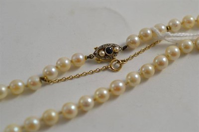 Lot 92 - A strand of cultured pearls with a sapphire and diamond set clasp