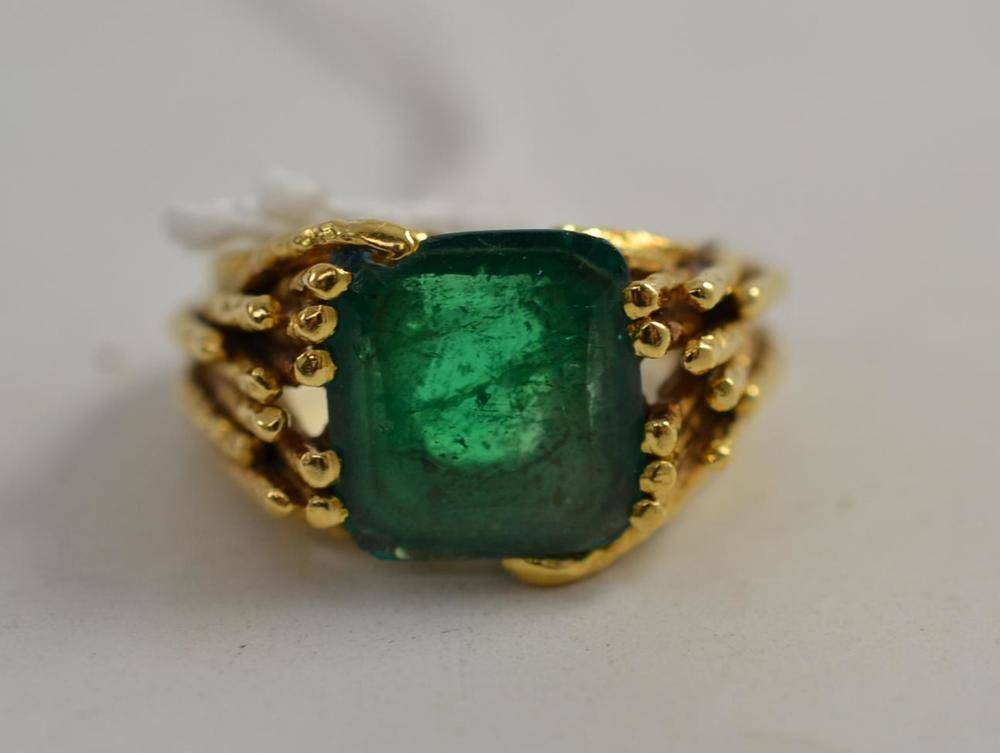 Lot 136 - An emerald ring, the step-cut emerald in a textured branched shoulder shank, finger size M