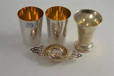 Lot 373 - A silver tea strainer, a Continental white metal flared beaker and two plated beakers