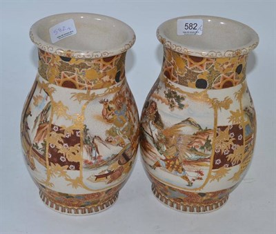 Lot 582 - A pair of late 19th century Japanese earthenware ovoid vases decorated with panels of warriors...