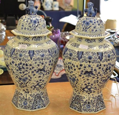 Lot 584 - A pair of 18th century Dutch Delft octagonal section blue and white vases with lion finials