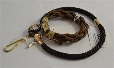 Lot 590 - A plaited hair albert, a plaited hair bracelet, a stud enclosing plaited hair, a hair ornament, and