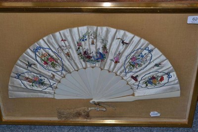 Lot 624 - A silk polychrome decorated fan in a glazed case