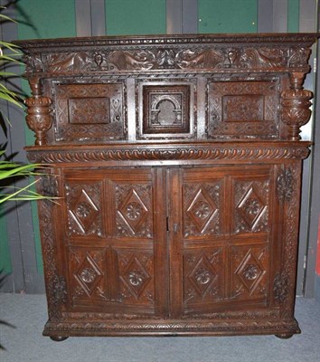 Lot 943 - An impressive carved oak court cupboard, the frieze richly carved with dragons and figural...